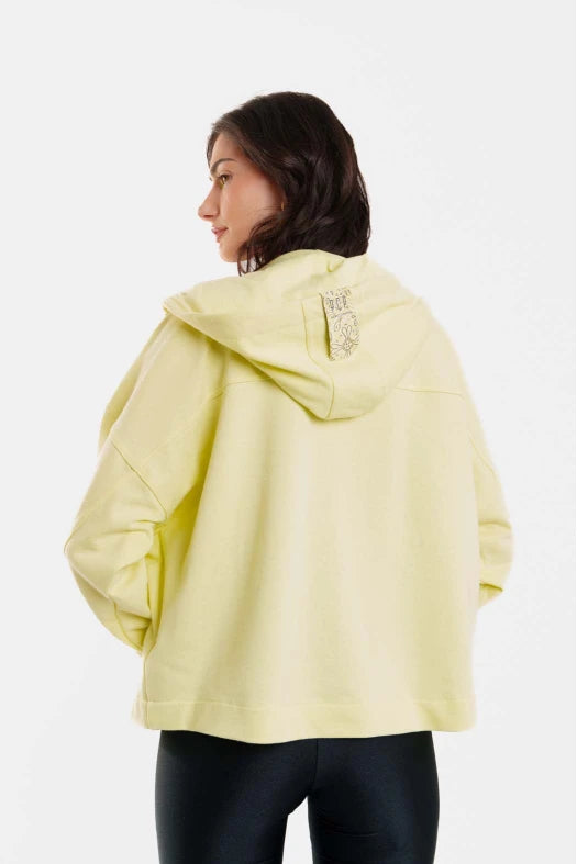Person wearing a light yellow jacket on a white background