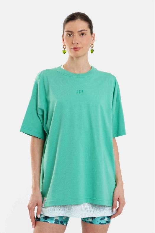 Person wearing a teal oversized t-shirt on a white background