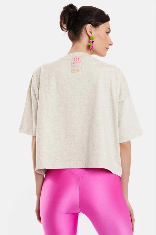 Woman wearing a grey oversized shirt and pink leggings on a white background