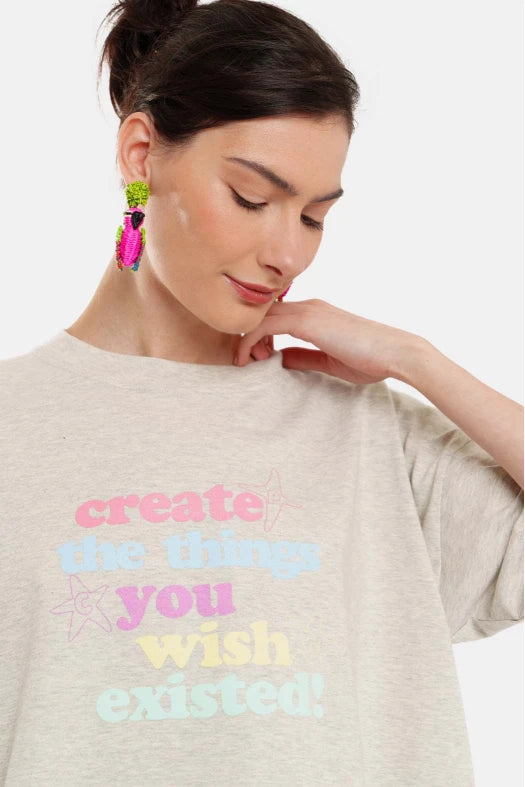 Woman wearing a gray t-shirt with colorful text on a white background