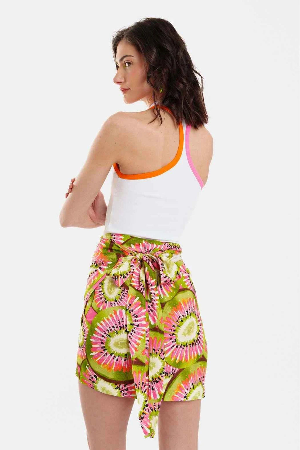 Woman wearing a colorful skirt with a white top on a white background