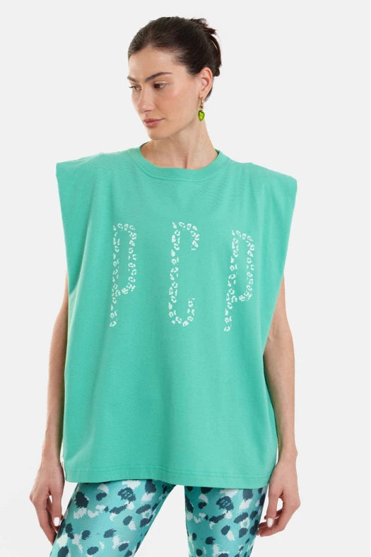 Woman wearing a turquoise sleeveless top with 'HAPPY' print and patterned pants on a white background