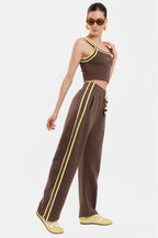 Woman wearing a brown outfit with yellow accents on a white background