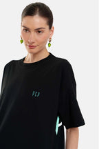 Woman wearing a black t-shirt with green text on a white background