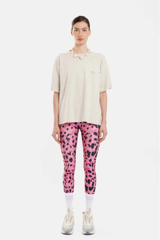 Person wearing a beige polo shirt and pink leopard print leggings on a white background