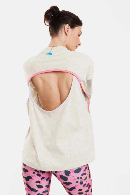 Woman wearing a light-colored sleeveless jacket with pink trim on a white background