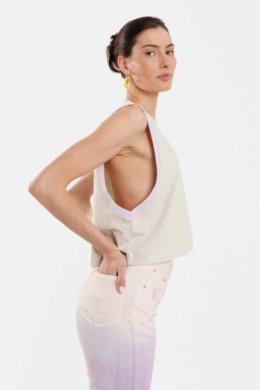 Woman wearing a white sleeveless top and pants on a white background