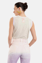 Woman wearing a sleeveless top with a visible brand logo on a white background