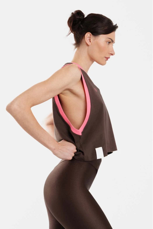 Woman wearing a brown outfit with pink accents on a white background