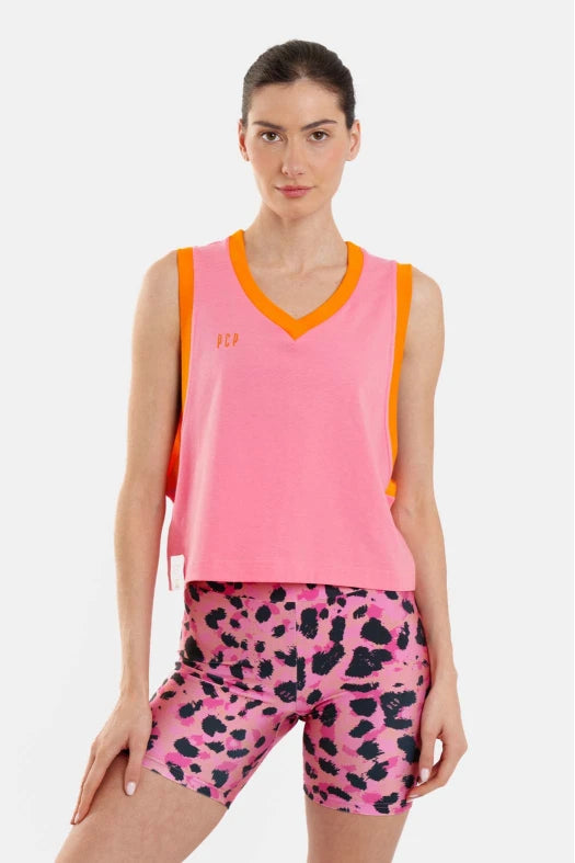 Woman wearing a pink sleeveless top and leopard print shorts on a white background