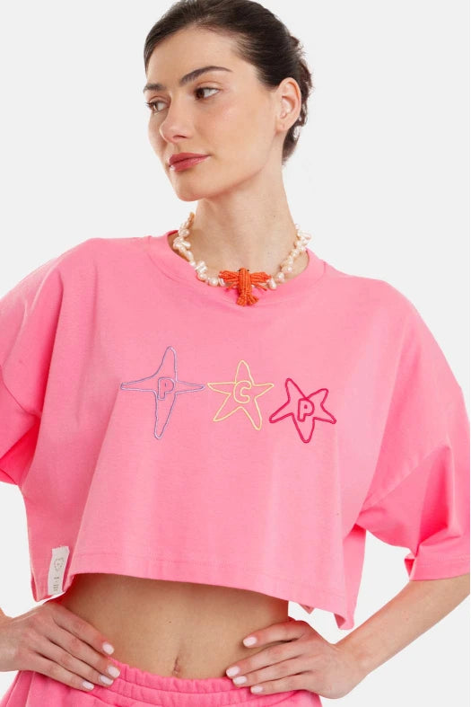 Person wearing a pink outfit with star designs on a white background
