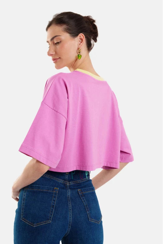 Woman wearing a pink top and blue jeans on a white background