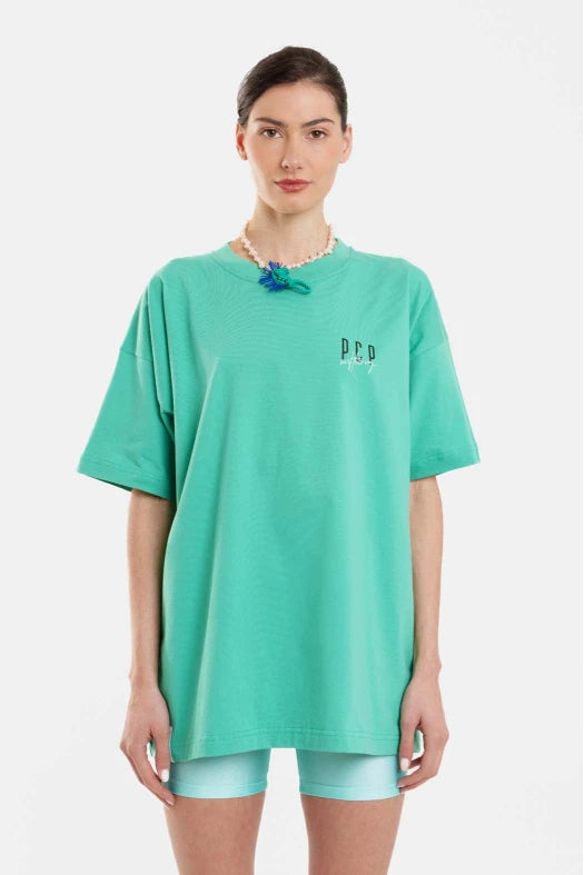 Person wearing a teal oversized t-shirt with 'PPL' branding on a white background