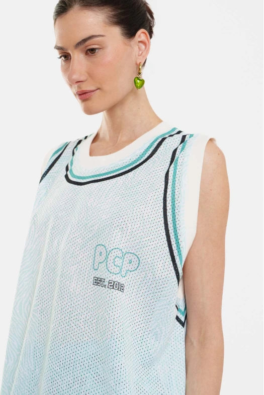 Woman wearing a light blue sleeveless top with black and green accents on a white background