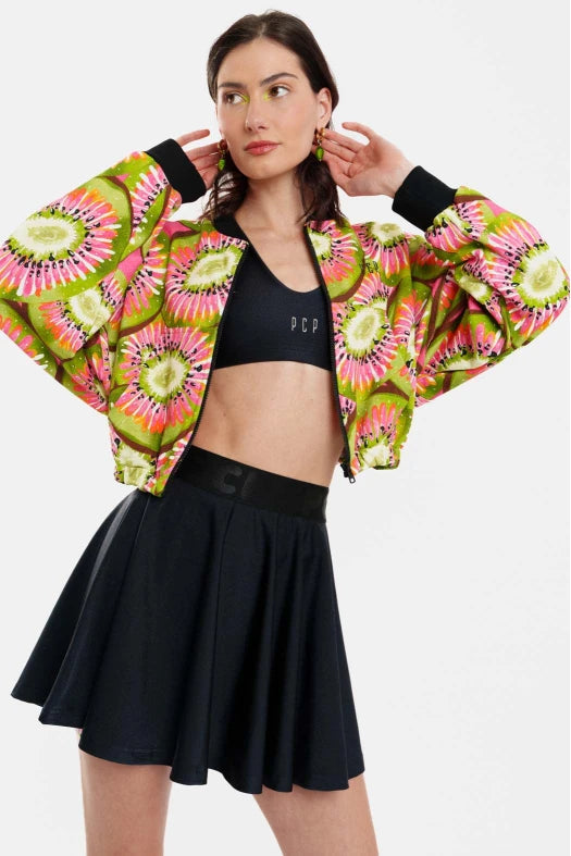 Woman wearing a colorful jacket with a black top and skirt on a white background