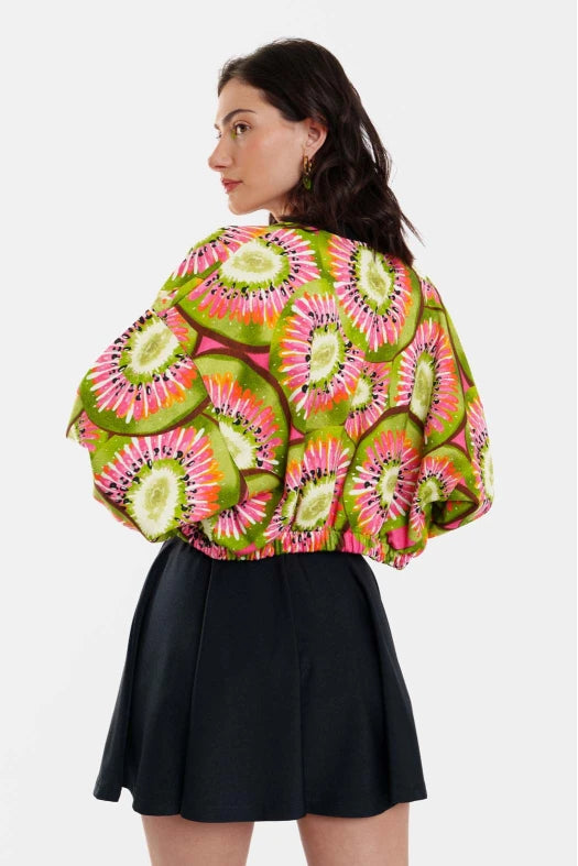 Person wearing a colorful patterned jacket with a plain background