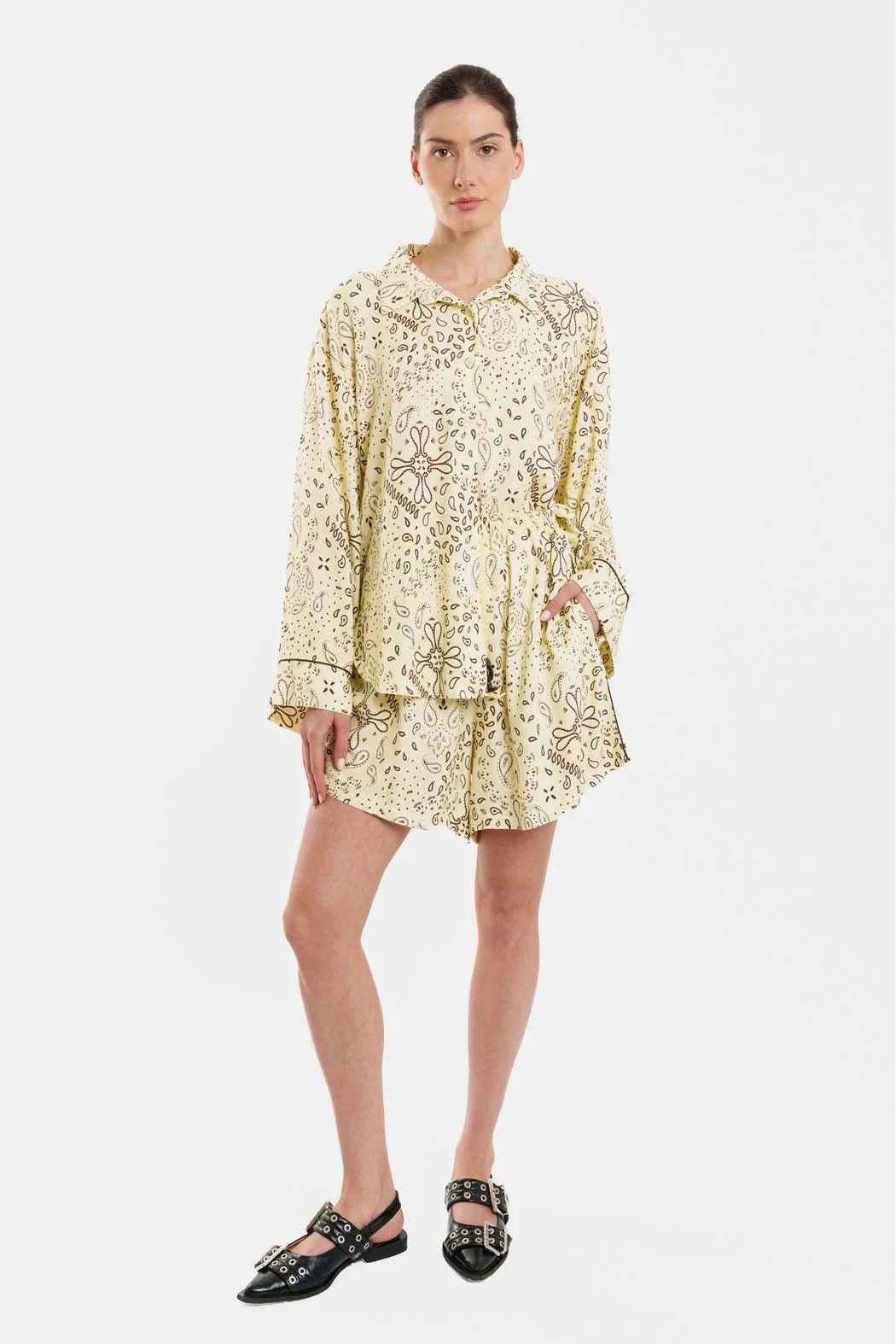 Woman wearing a yellow patterned dress on a white background