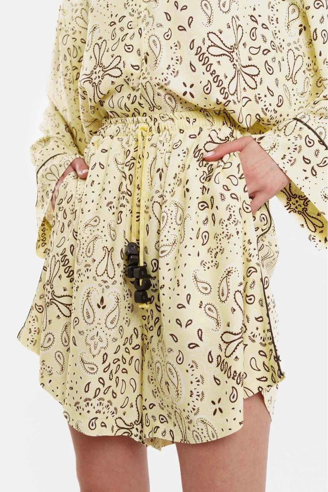 Person wearing a yellow patterned outfit with a white background