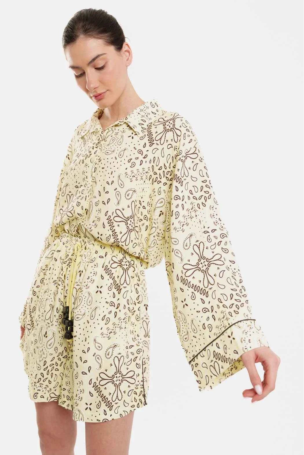 Woman wearing a yellow floral dress on a white background