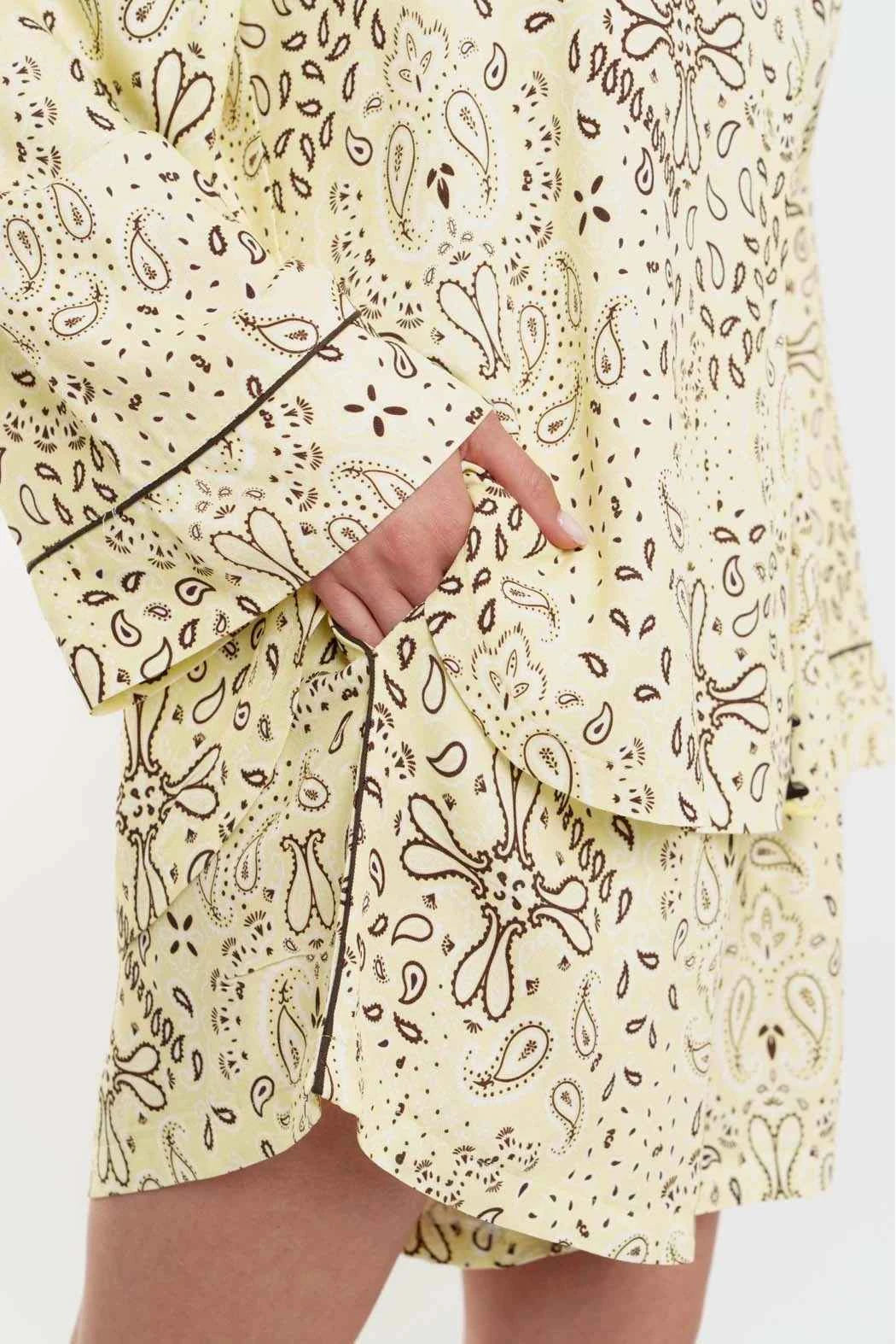 Light yellow pajama set with black paisley pattern on a white background