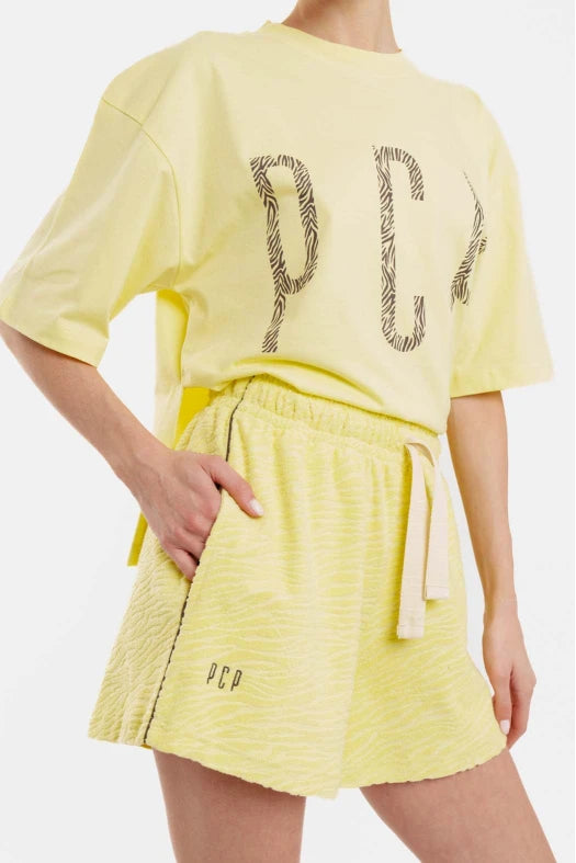 Person wearing a yellow outfit with 'PCP' branding on a white background