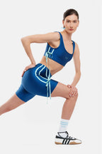 Woman in blue athletic outfit posing on a white background