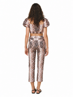 A model viewed from the back wearing a matching two-piece leopard print set with puff sleeves and cropped pants, on a plain white background.