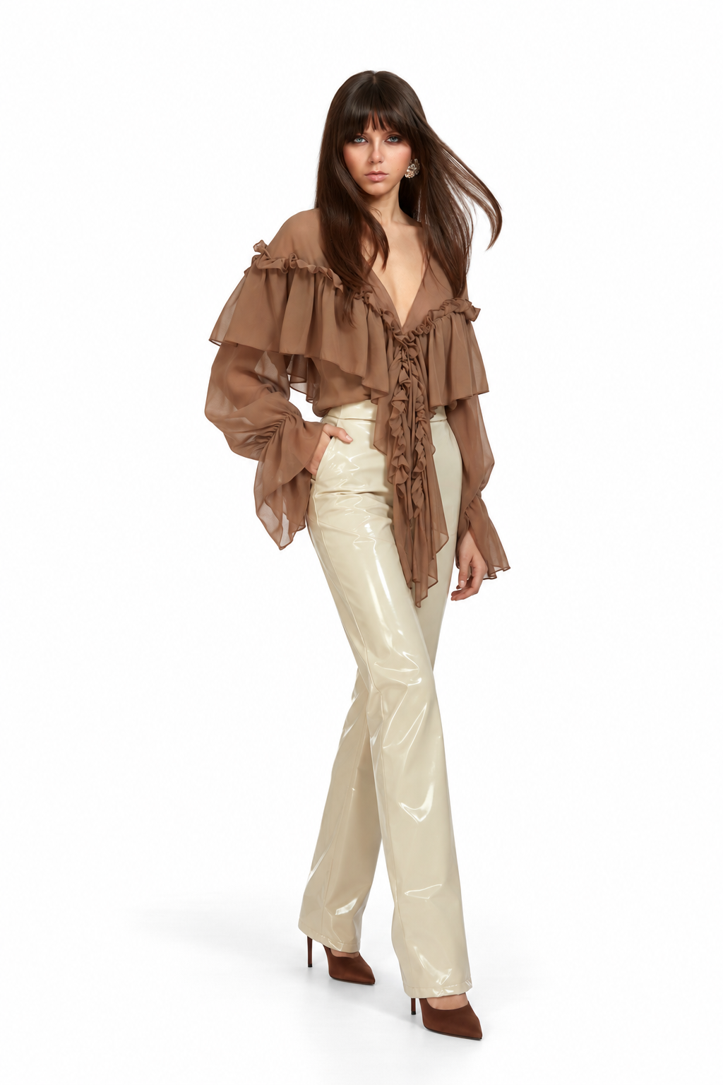 A model wearing a brown ruffled long-sleeve blouse with a lace-up front and cream shiny flared pants, paired with brown pointed-toe heels, against a plain white background.