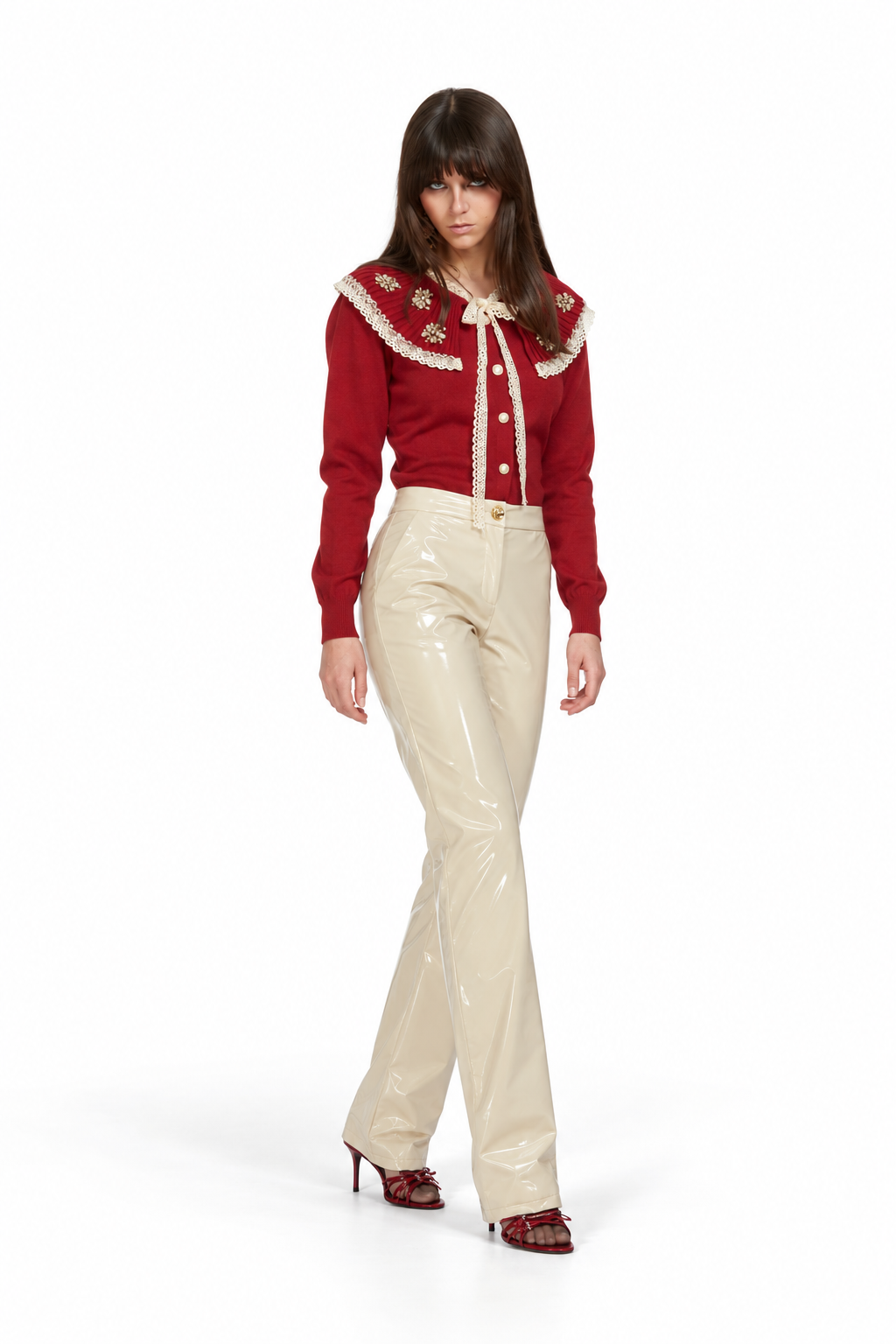 Odi Odi Mango Trousers in glossy cream with flared legs and a button waist, styled on a model with a red cardigan and heels.