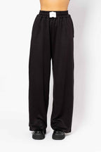 Black pants worn by a person on a white background