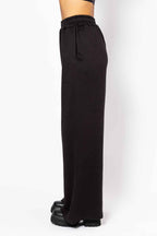 Black wide-leg pants with a tie waist on a white background