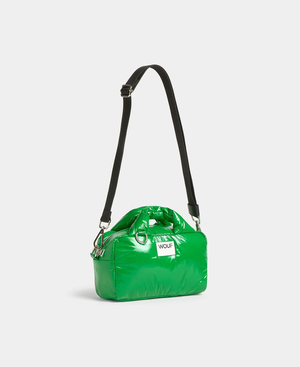 Green handbag with a black strap on a white background