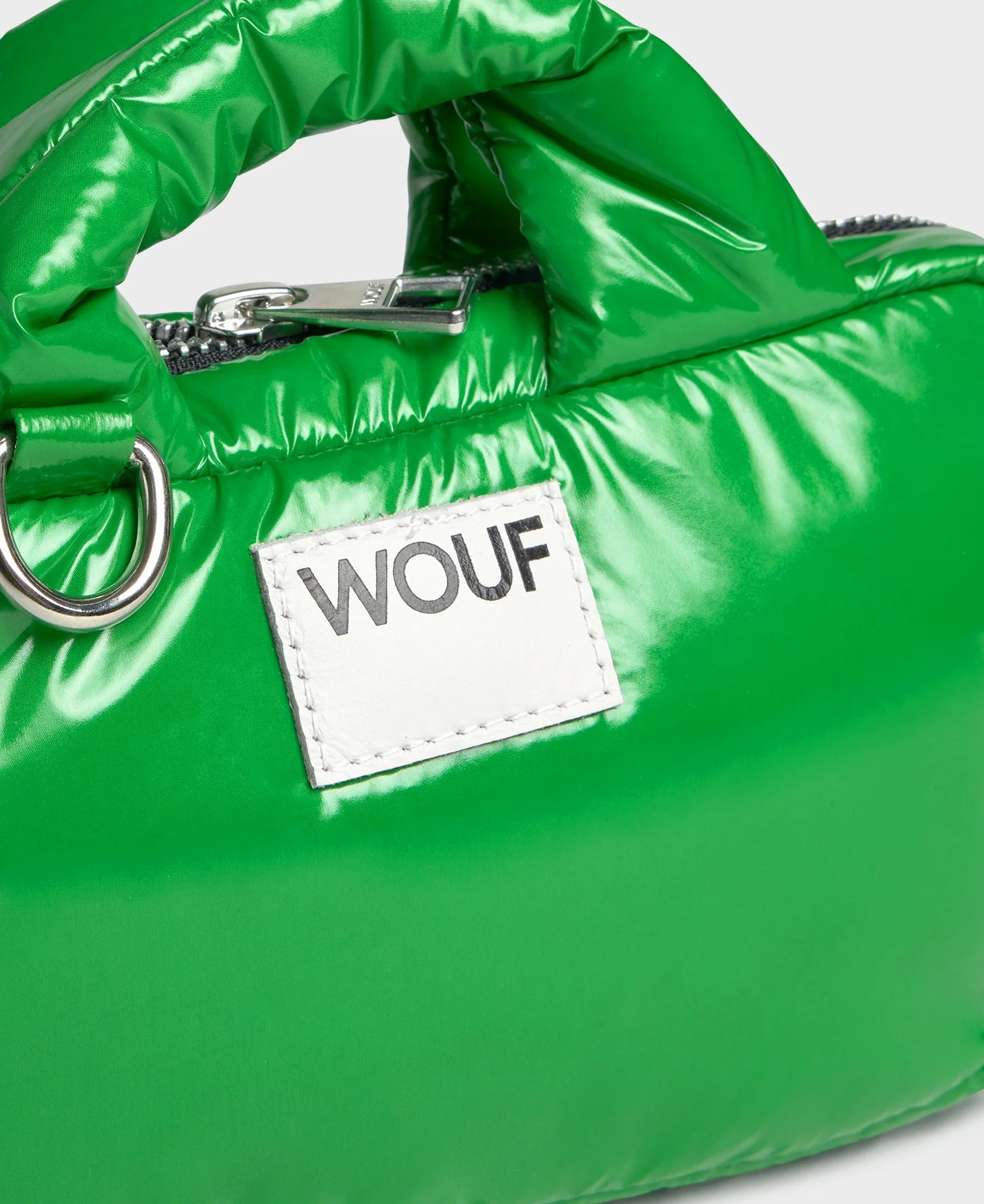 Green puffer bag with a WOUF label on a white background