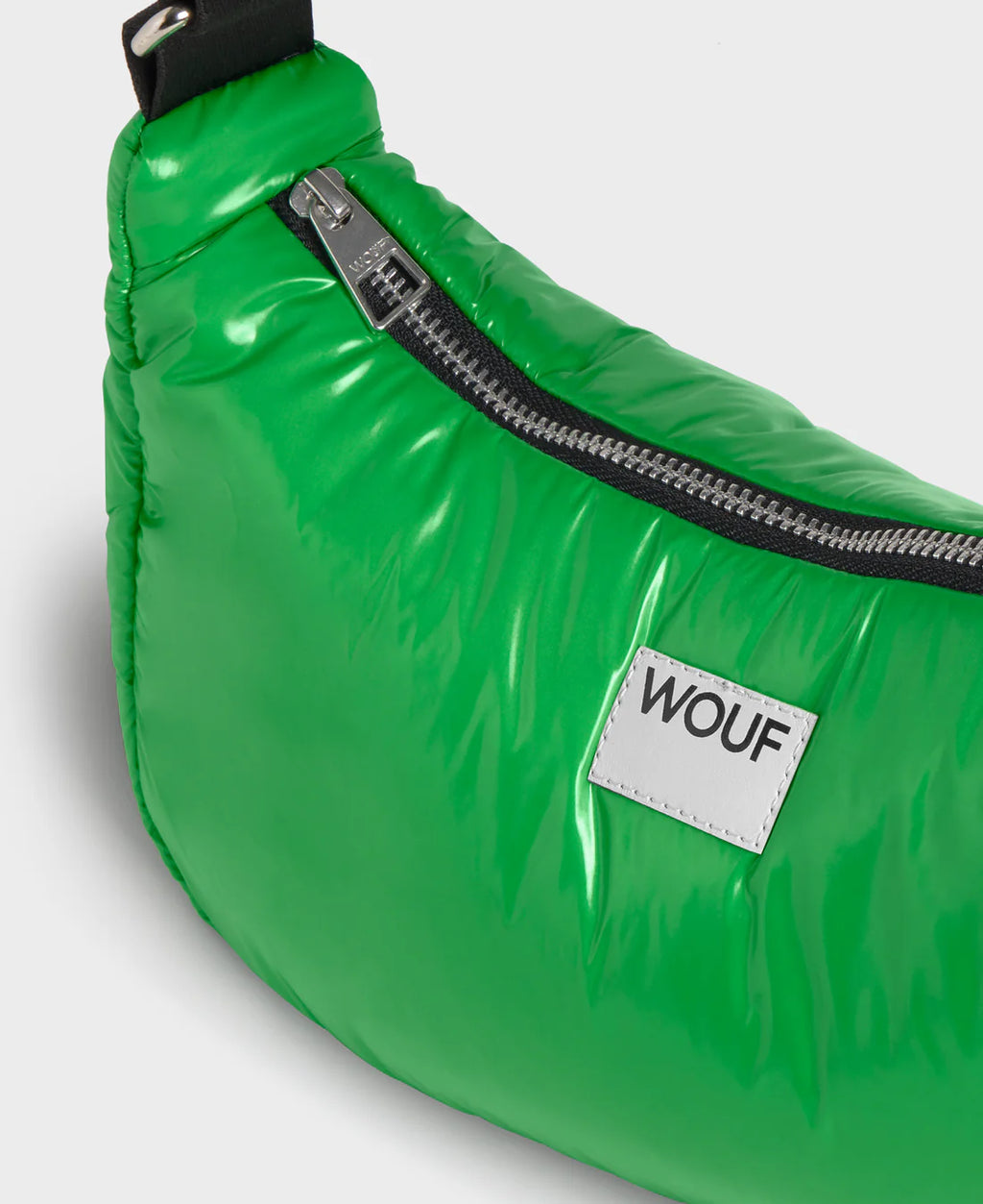 Green waist bag with a visible brand label on a light gray background