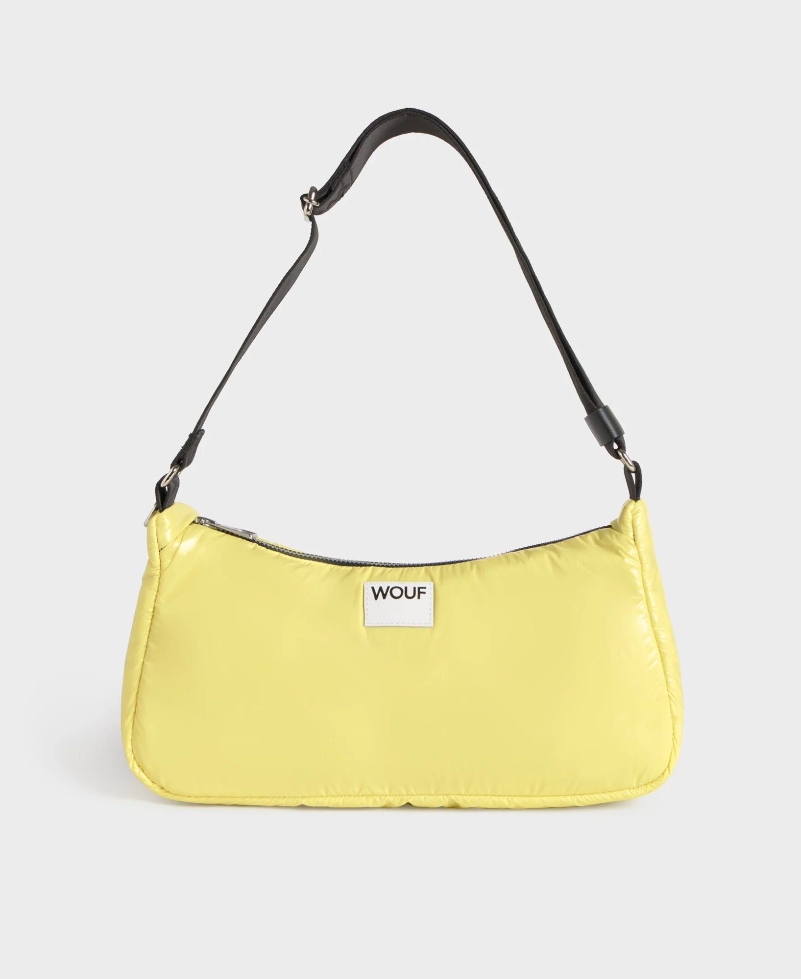 Yellow handbag with a black strap on a light gray background