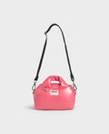 Pink handbag with a black strap on a light gray background