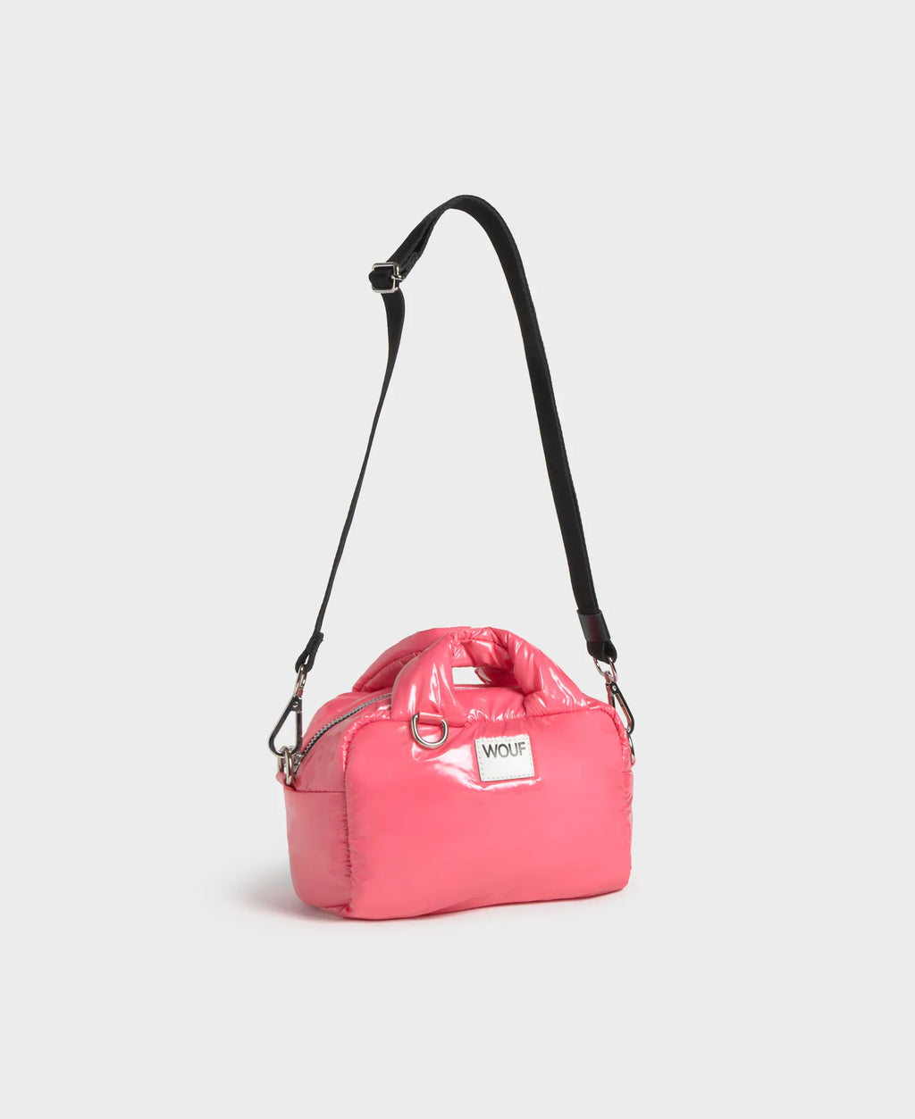 Pink bag with a black strap on a light gray background