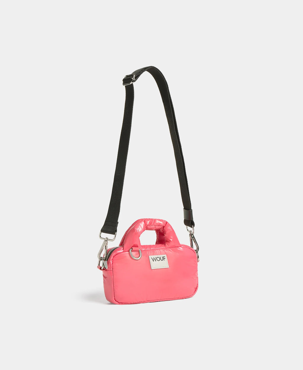 Pink handbag with a black strap on a light gray background