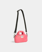 Pink handbag with a black strap on a light gray background