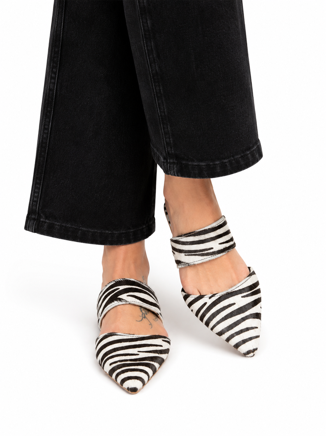 Sandalista Bianconero black and white zebra print leather mules with pointed toe worn with wide-leg black jeans front view