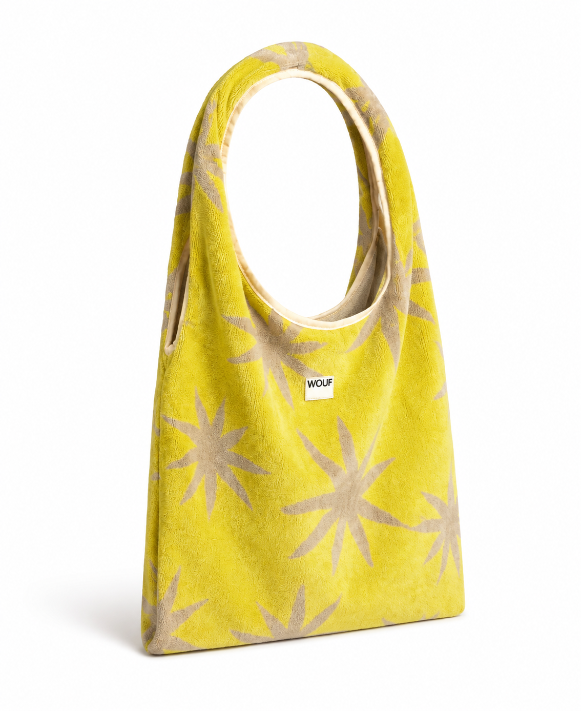 WOUF Fuerteventura T-Shirt Bag in yellow-green terry cloth with beige star print angled view showing structured base and silicon label