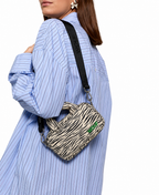 WOUF Zebra Hit Mini Bag worn as crossbody with black logo strap over blue striped shirt