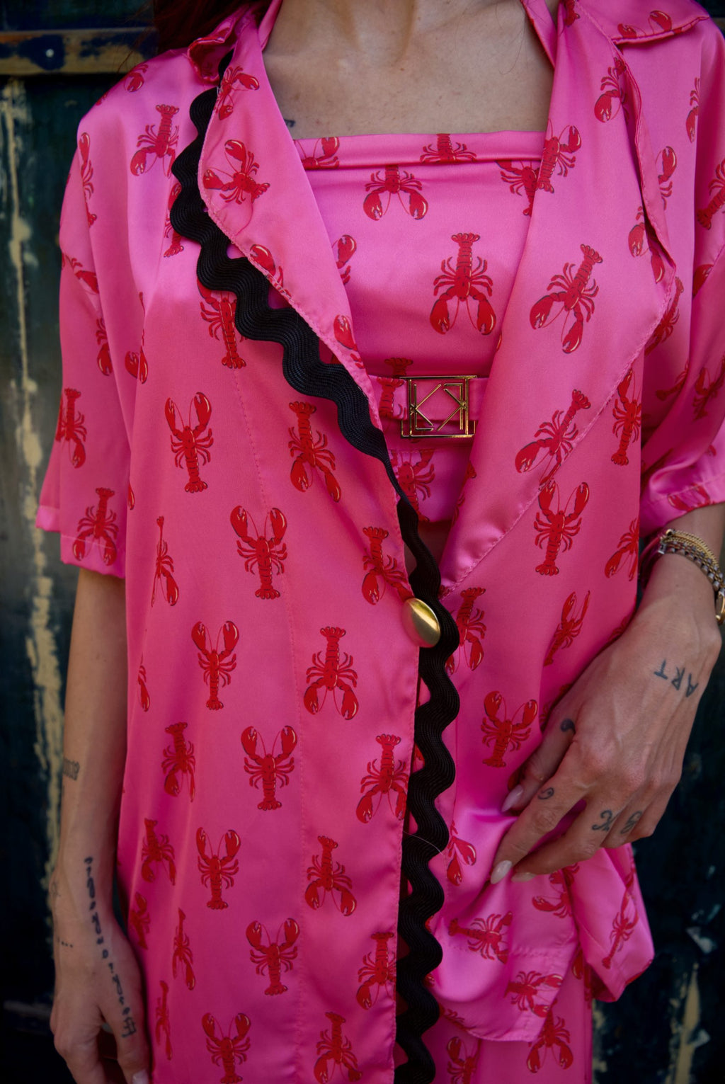 Person wearing a bright pink outfit with red patterns and black trim.
