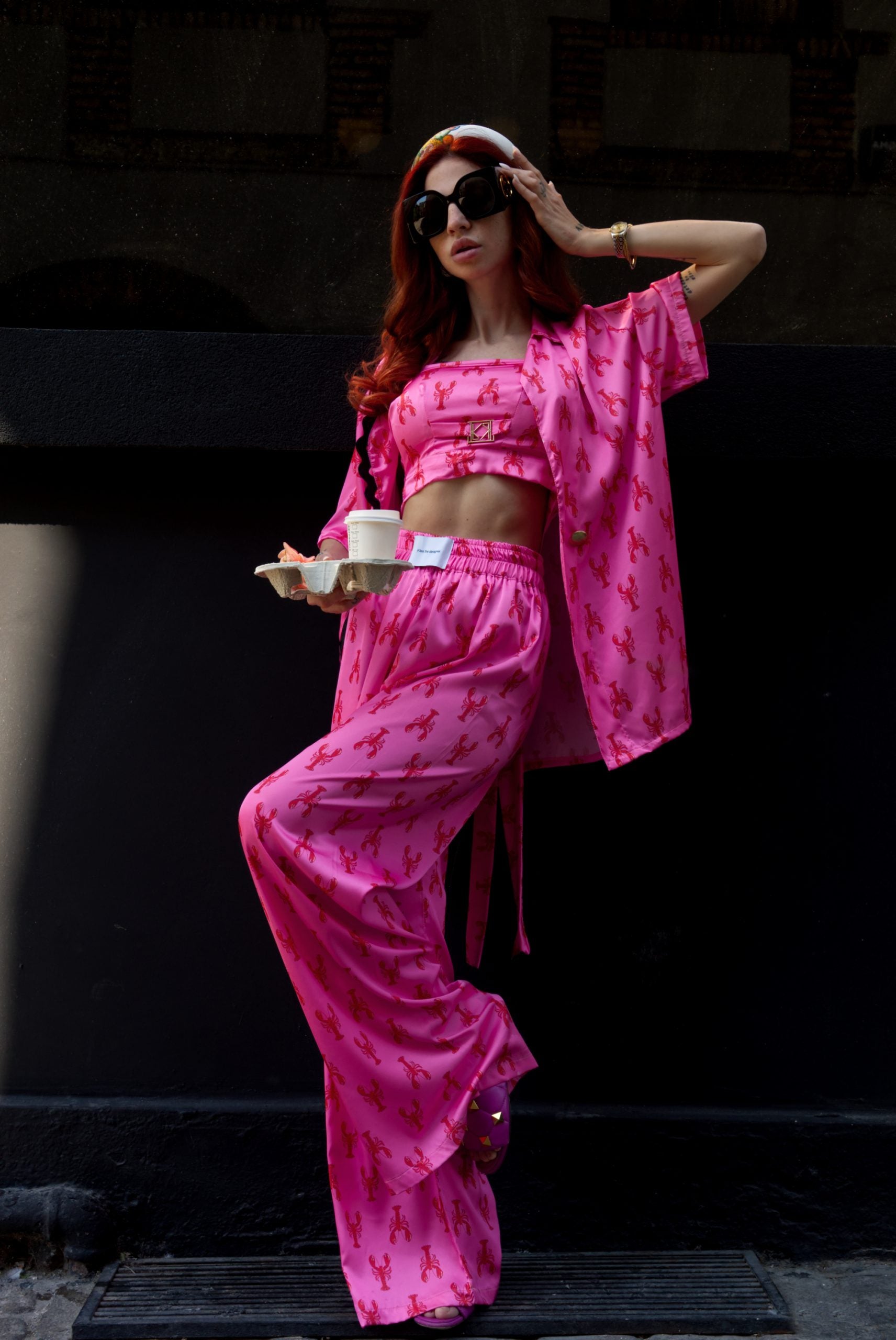 Woman in a pink outfit with a dark background
