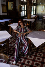 Woman sitting at a table in a restaurant with patterned floor and decor.