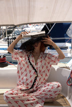 Person wearing a red and white patterned outfit on a boat