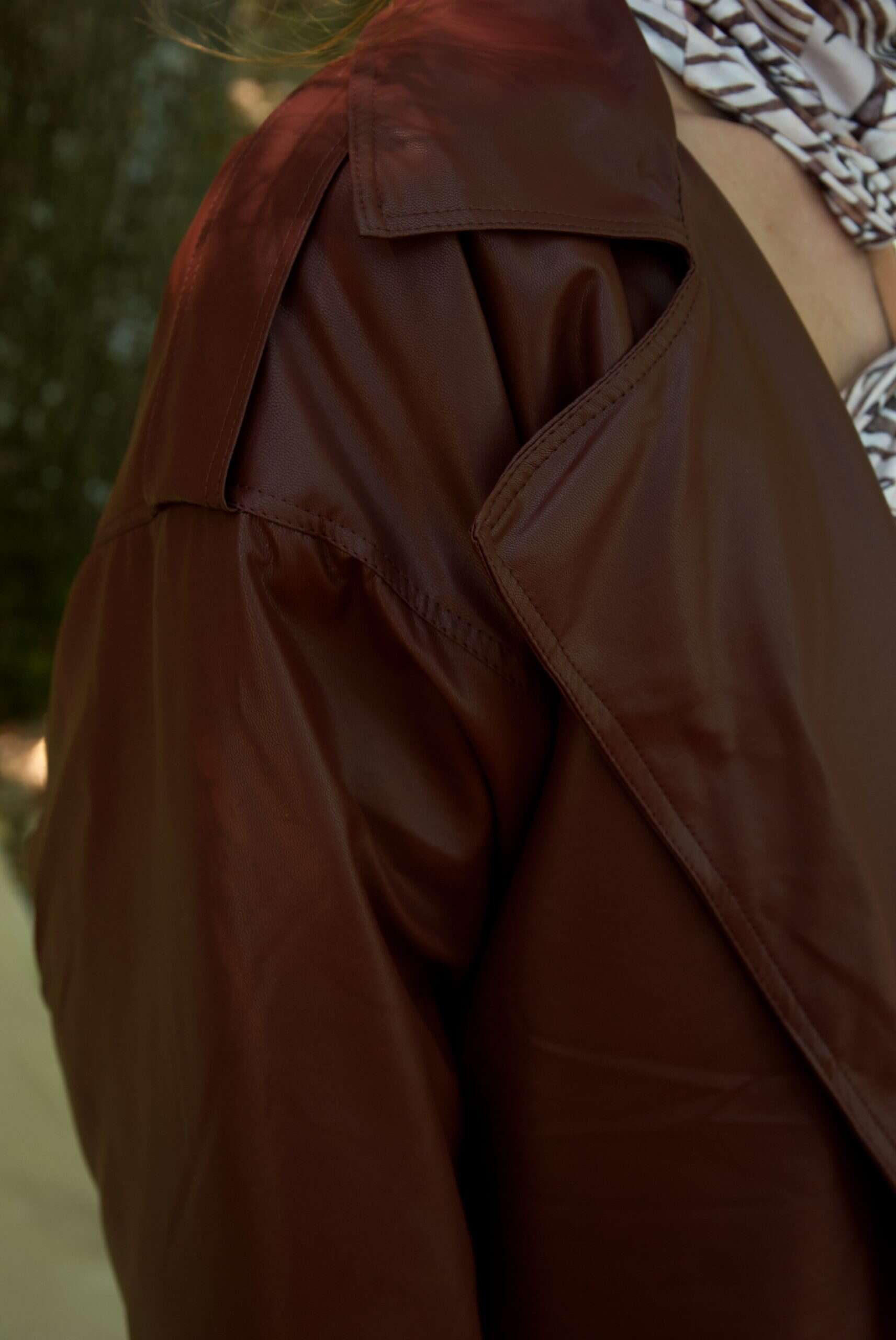 Brown jacket worn by a person with a blurred background