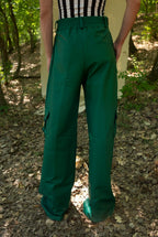 Person wearing green pants standing in a forest setting