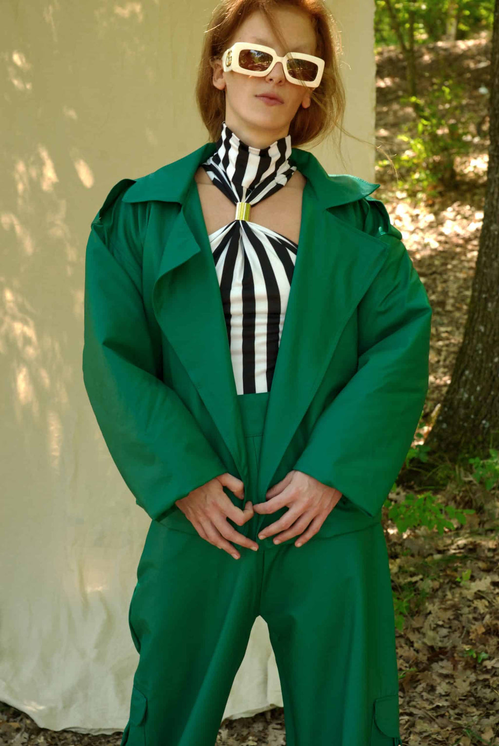 Person wearing a green outfit with a striped top outdoors
