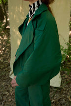 Person wearing a green suit with a zebra-striped shirt in a forest setting